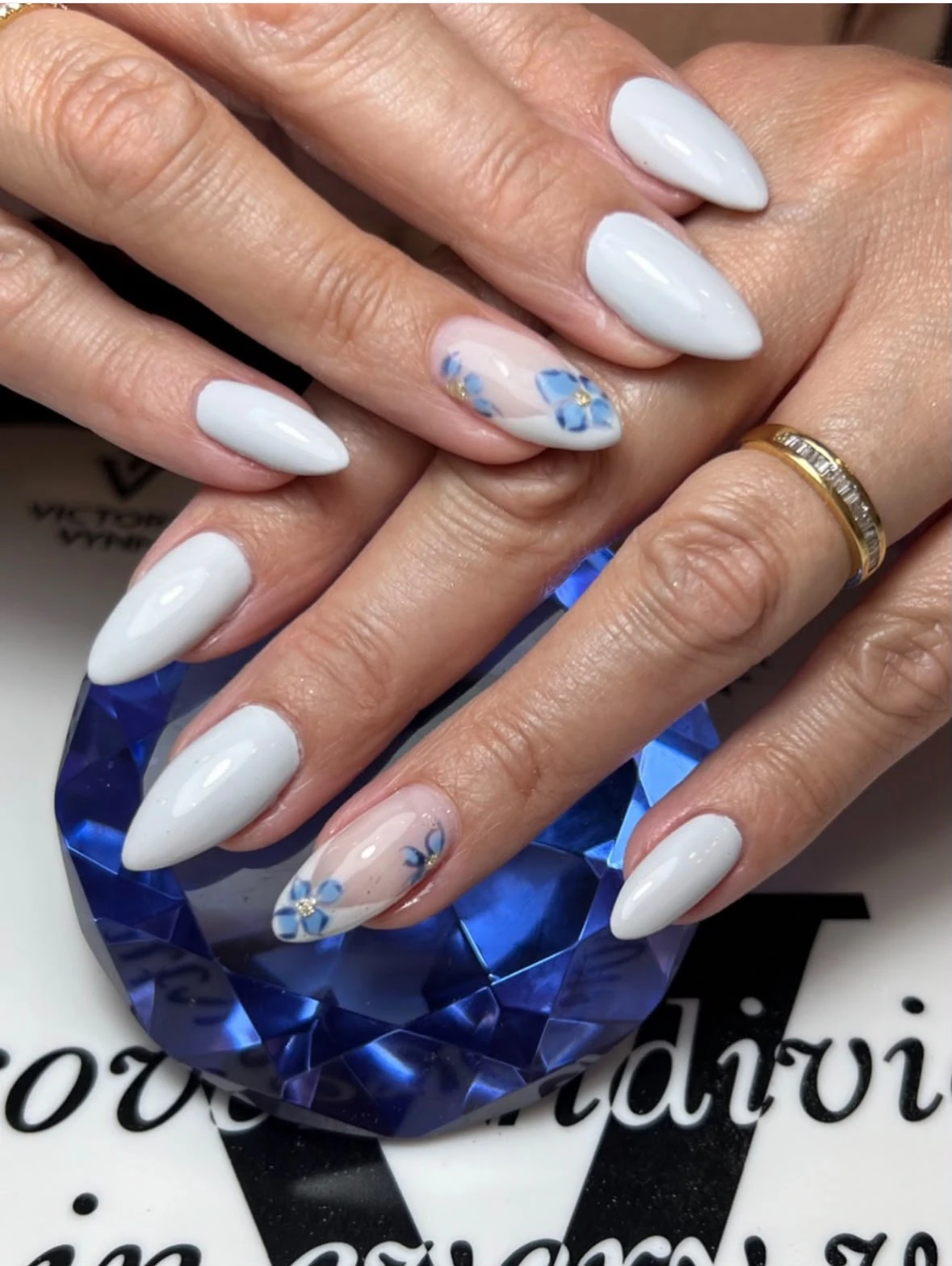 Manicura blanca con flores azules